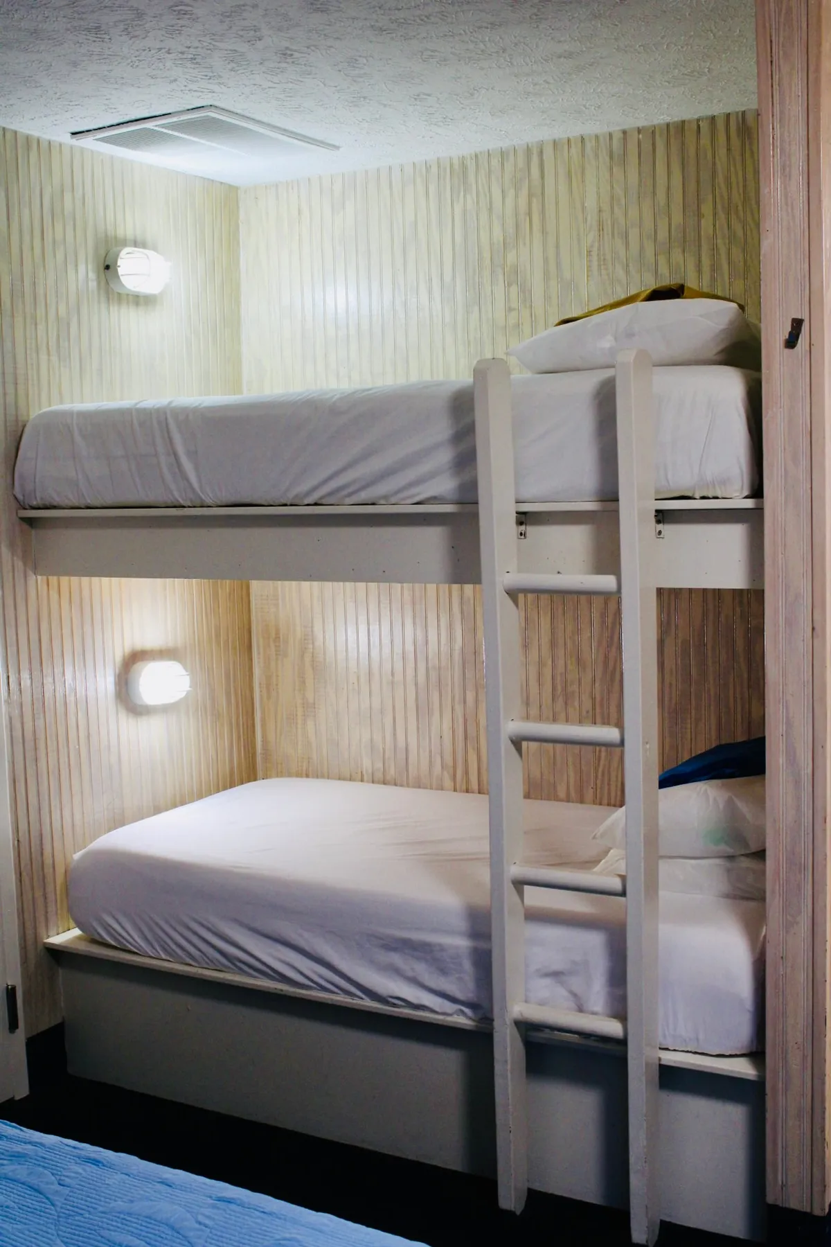A playful nook with bunk beds and a ladder, featuring soft linens and a cozy atmosphere. The arrangement invites family bonding, games, and movie nights, supporting a sense of togetherness.